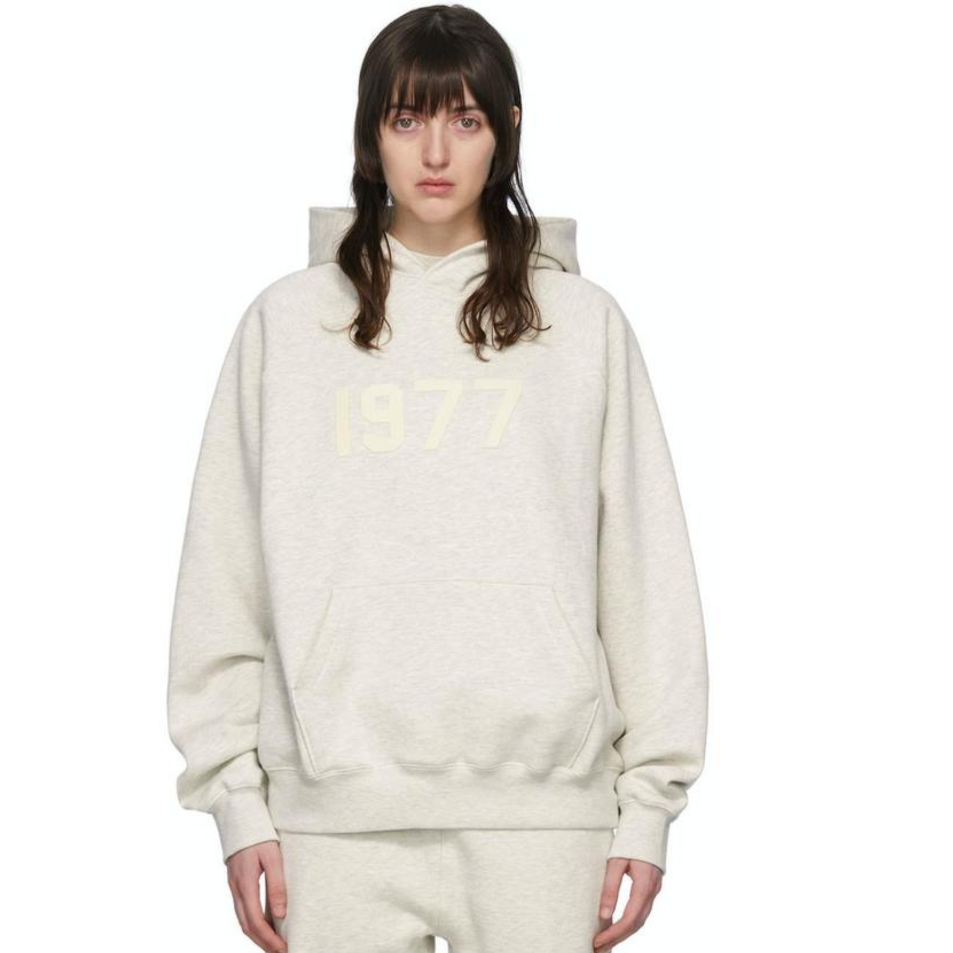 Fear of God Essentials 1977 hoodie in light oatmeal worn by model