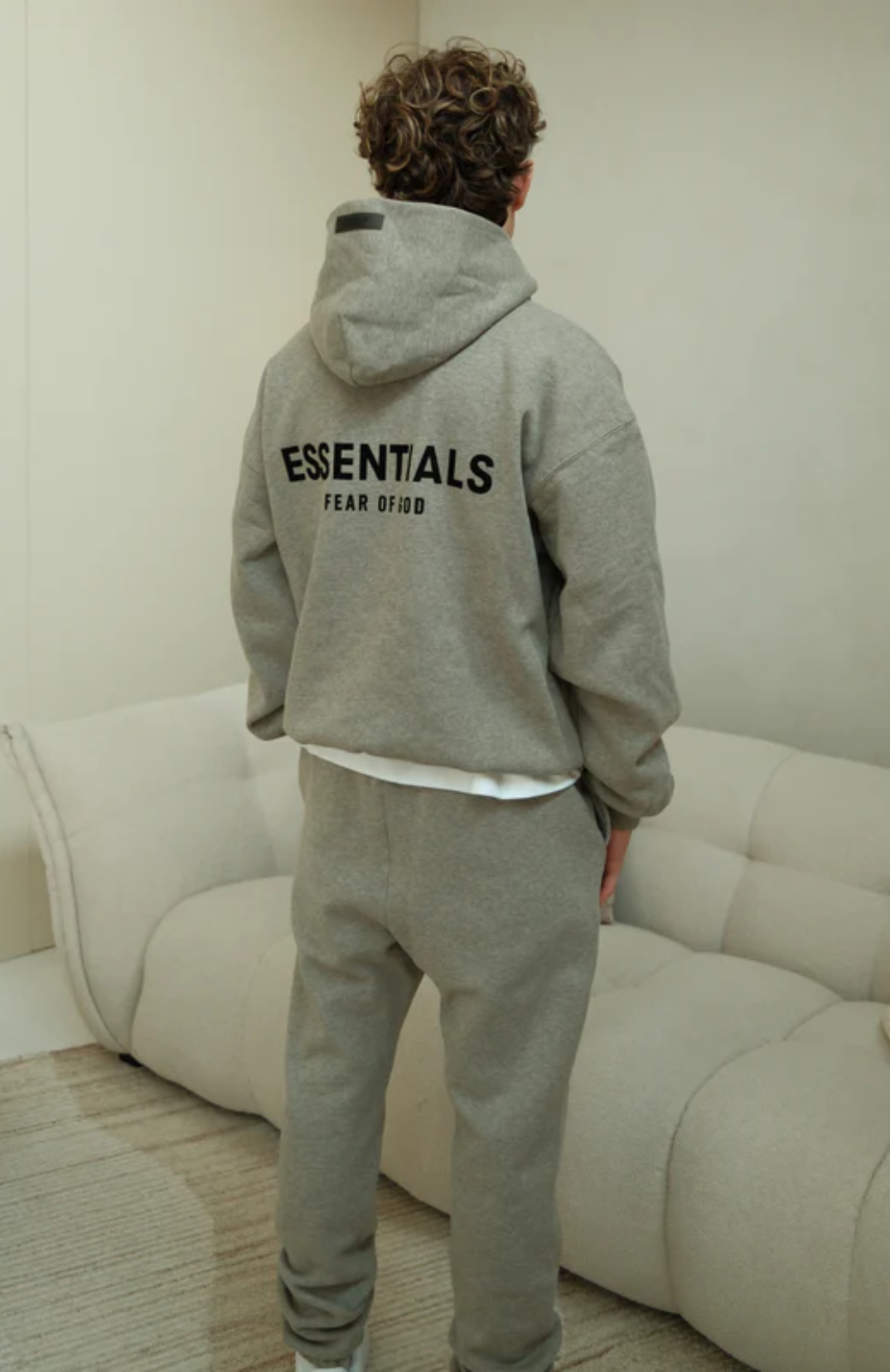 Fear of God ESSENTIALS hoodie and sweatpants set in dark oatmeal worn by model back view