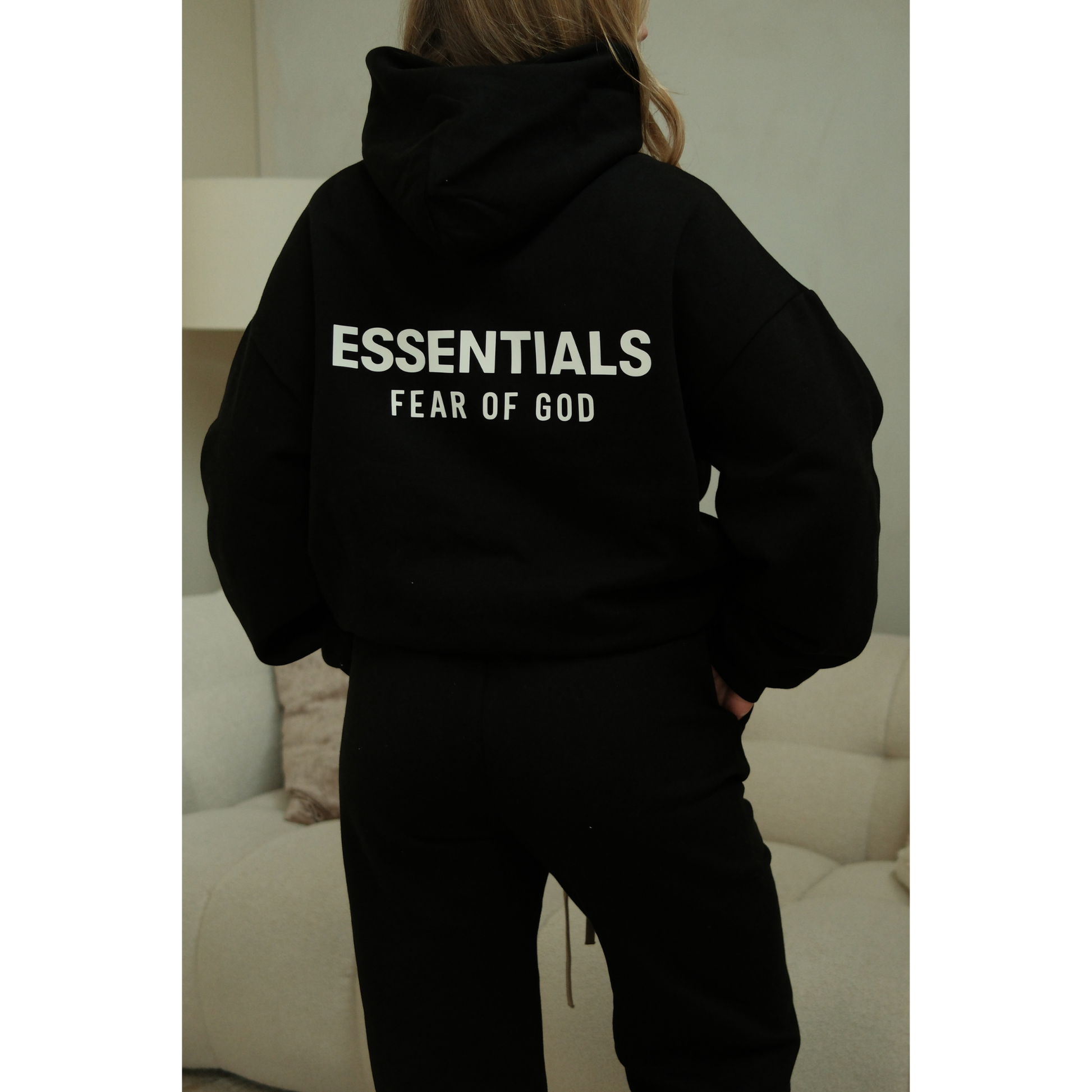 Fear of God Essentials FW24 hoodie in black worn by model back view