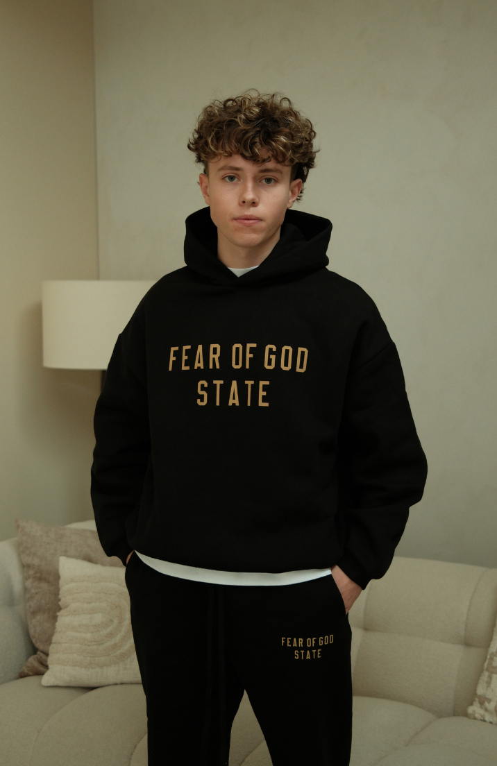 Fear of God ESSENTIALS hoodie and sweatpants set in black worn by model front view