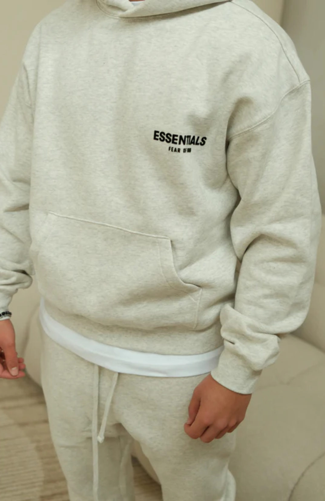 Fear of God ESSENTIALS Light Oatmeal Full Set hoodie in light oatmeal worn by model detail view
