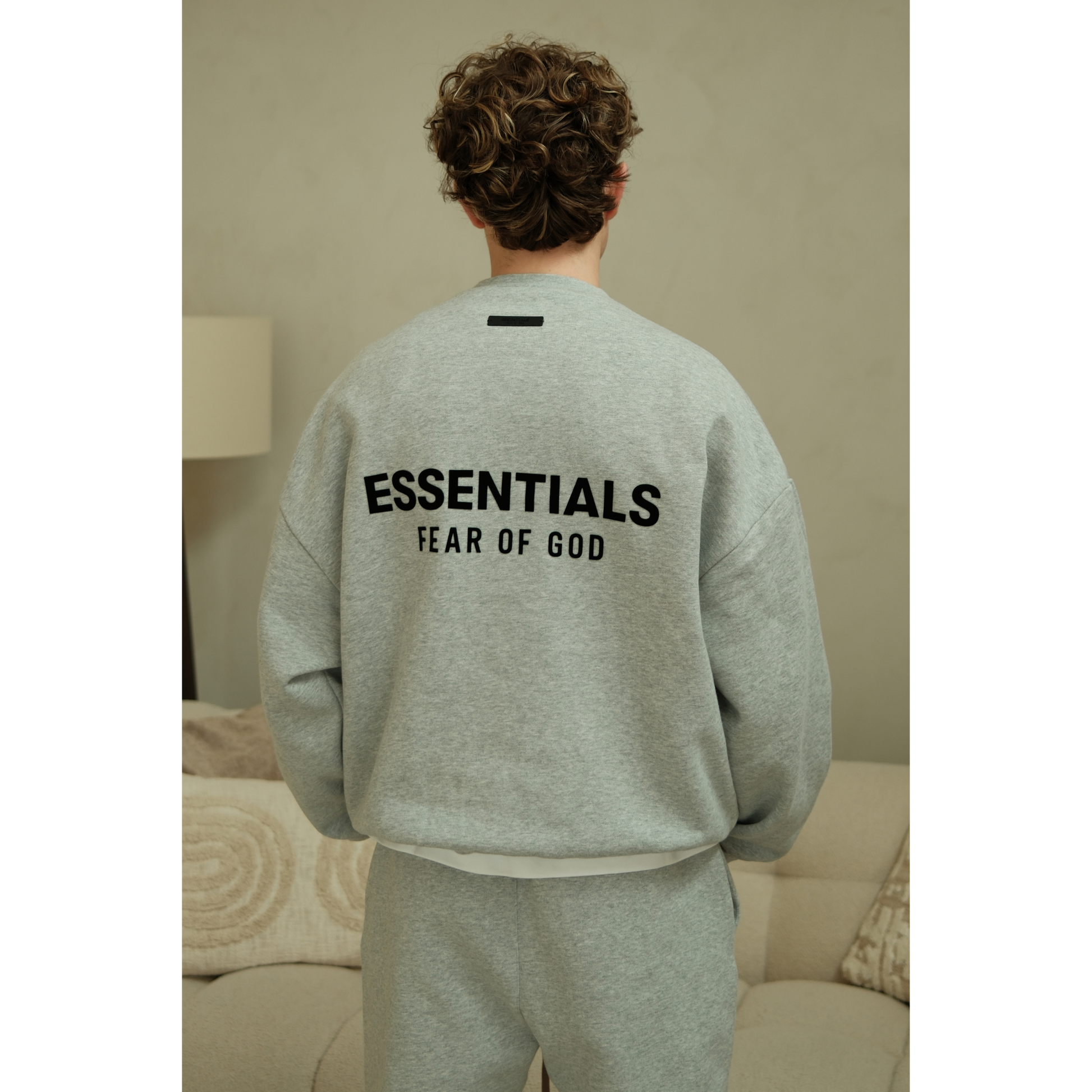 Fear of God Essentials mens fleece crewneck in heather grey worn by model back view