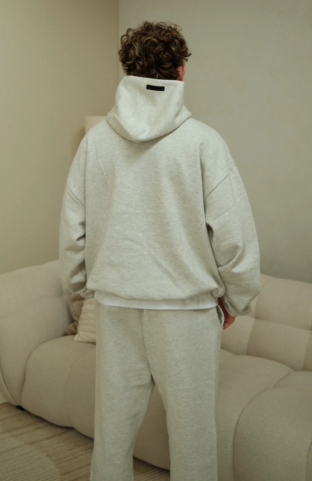 Fear Of God Essentials NBA hoodie and sweatpants set in light heather worn by model back view