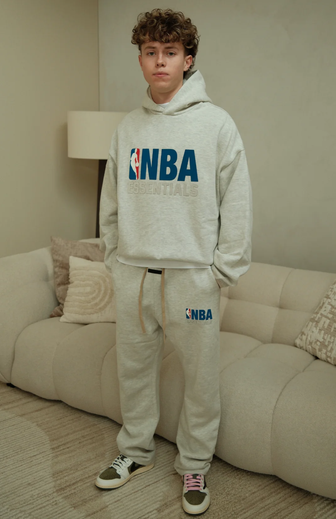 Fear Of God Essentials NBA hoodie and sweatpants set in light heather worn by model front view