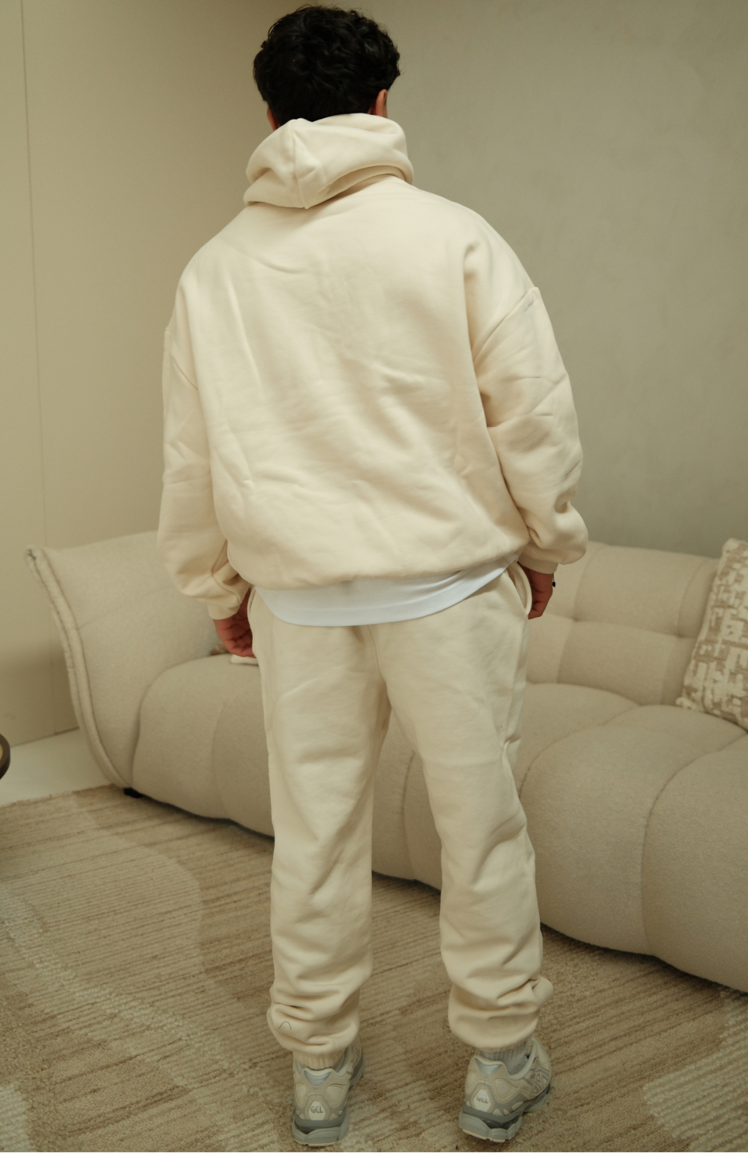 Fear of God Essentials Shell hoodie in cream back view worn by model
